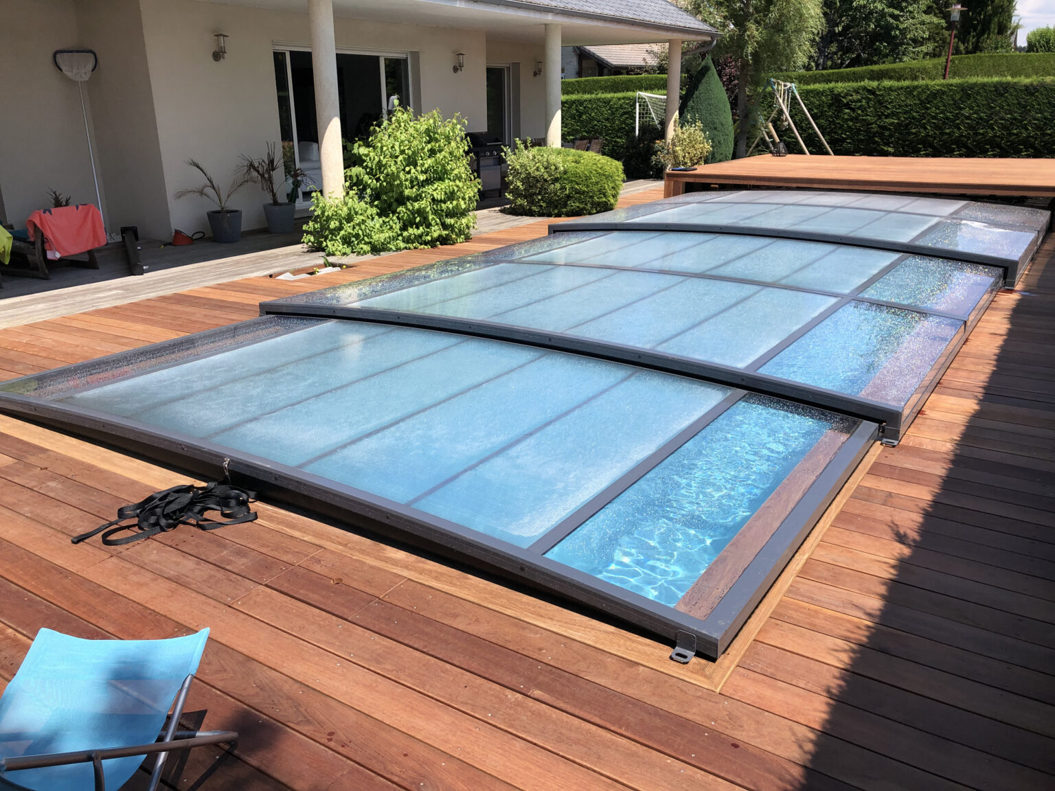 Concept Outdoor : piscine avec abri plat se rangeant complètement sous terrasse
