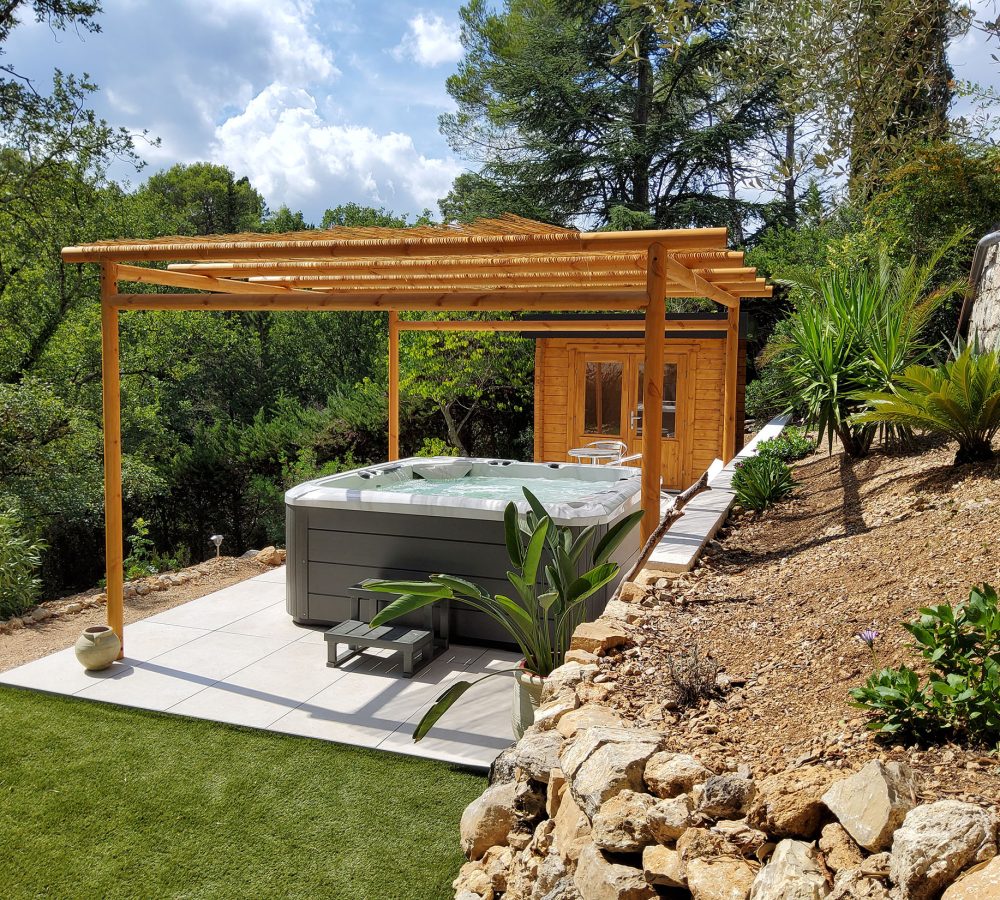 Espace extérieur avec un spa sous une pergolas